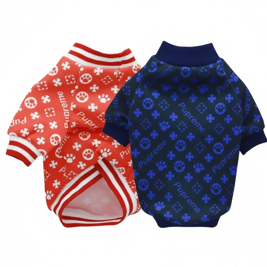 Two dog shirts, one red with white patterns and the other blue with black patterns, on a white background.
