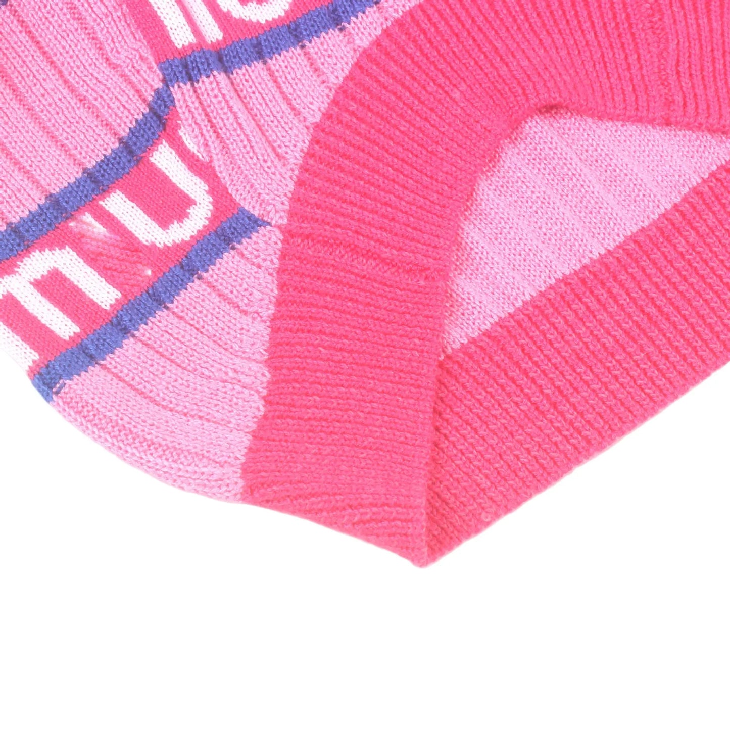 Close-up of a pink knitted garment with visible branding on a white background