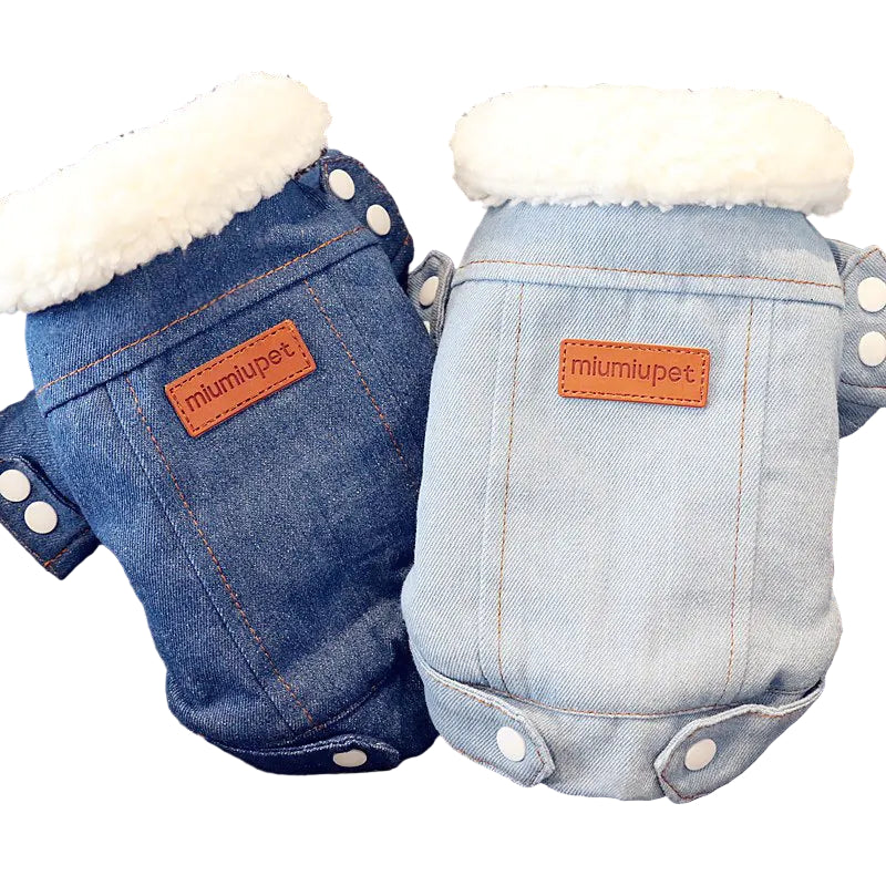 Two denim-style pet rompers with white fur lining on a textured surface