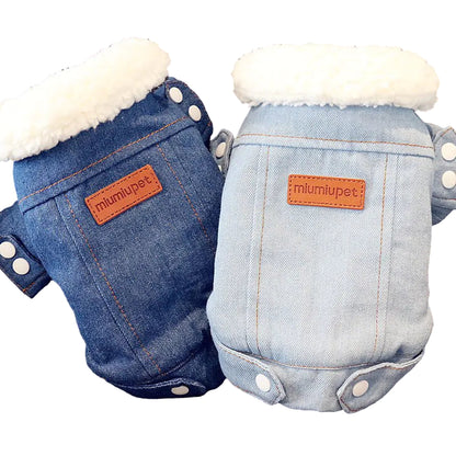 Two denim-style pet rompers with white fur lining on a textured surface