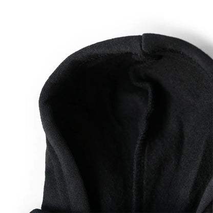 Close-up of a black hooded garment on a white background