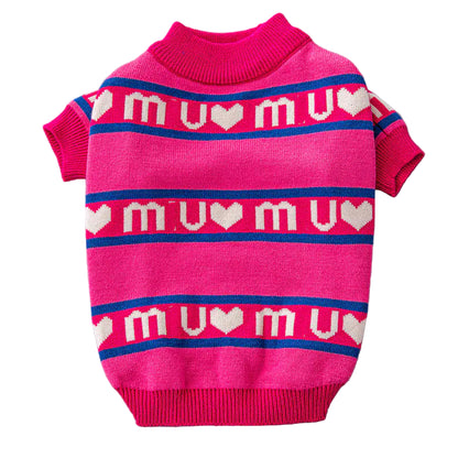 Pink dog sweater with 'mu mu' pattern on a gray surface