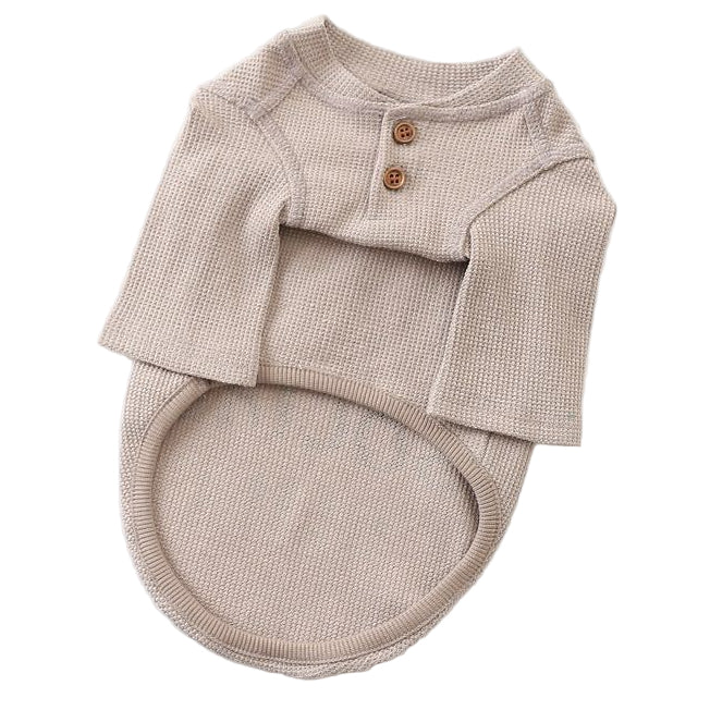 Beige baby outfit with buttons on a white background