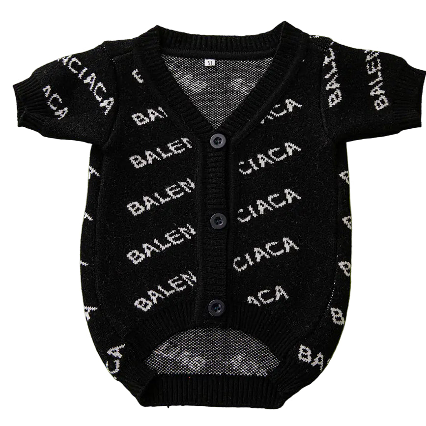 Black baby cardigan with white text on a green background