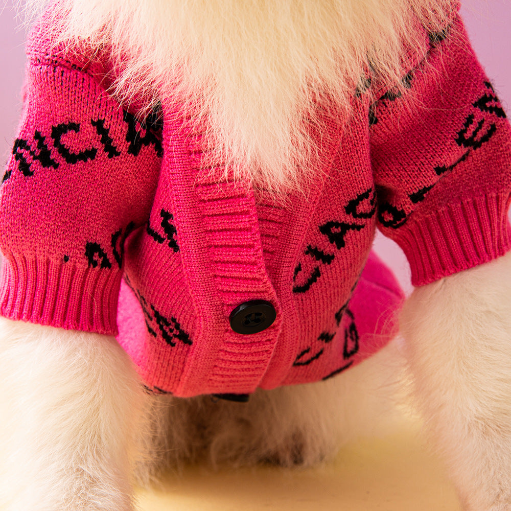 Close-up of a dog wearing a pink sweater with black text on a light purple background