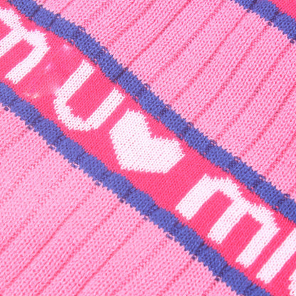 Close-up of pink fabric with white text and purple border