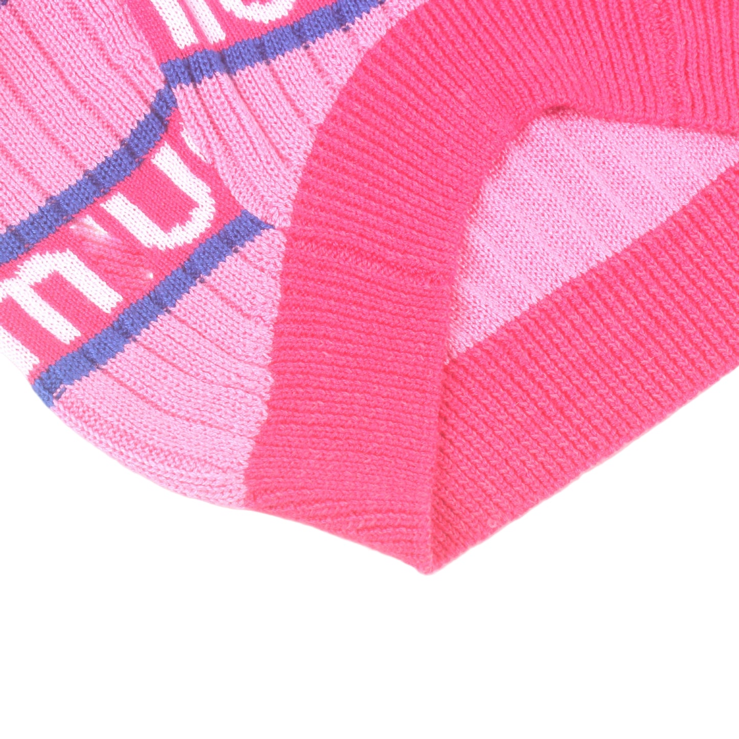 Close-up of a pink knitted garment with visible branding on a white background