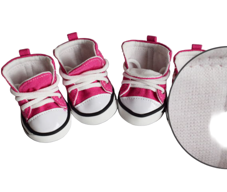 Set of baby shoes with pink and white design on a gray surface