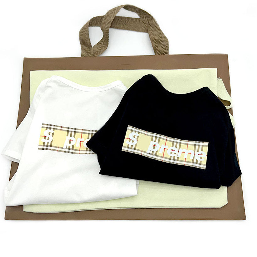 Folded clothes on a brown paper bag with a plaid pattern