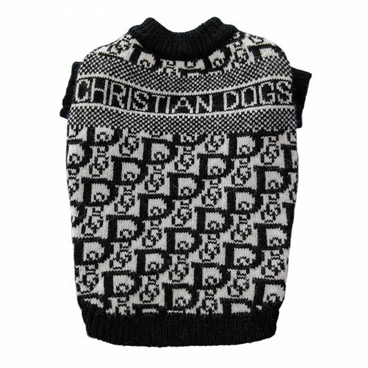 Black and white patterned dog sweater on a blue surface with a book in the background