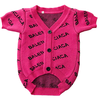 Pink baby outfit with black text on a green background